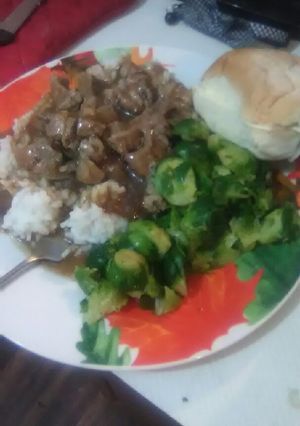 A picture of Pork Tips and Onions over White Rice.