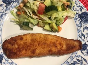 Una foto de Tilapia empanizada con ensalada fresca