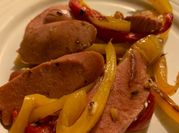 Una foto de salchicha con pimiento y cebolla