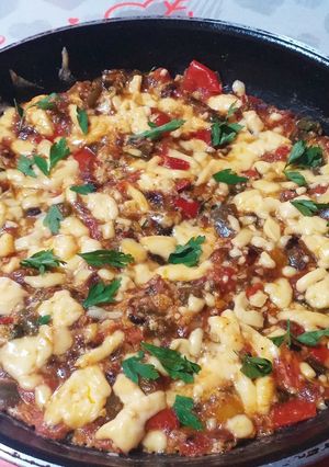 A picture of Shakshuka with Eggs and Cheese.