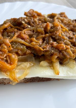 Una foto de Tosta de berenjena mechada, cebolla caramelizada y queso
