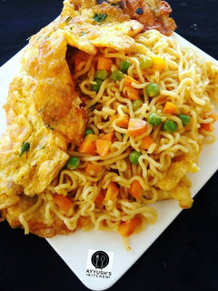A picture of Jollof Vegetable noodles with fried eggs.