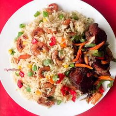 A picture of Coconut rice garnished with shrimps and vegetables.