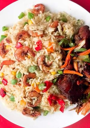 A picture of Coconut rice garnished with shrimps and vegetables.