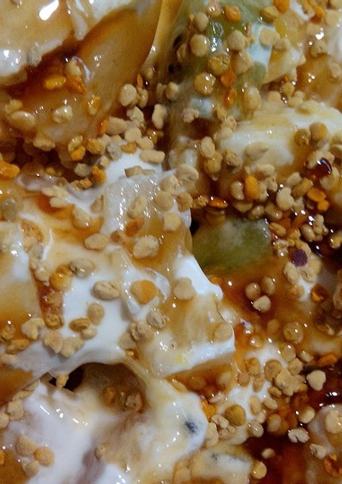 Una foto de Macedonia de frutas con yogurt, polen y miel