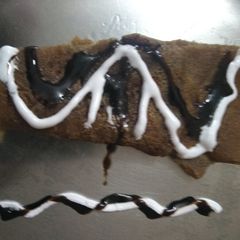 A picture of Jaggery pancake with chocolate syrup.