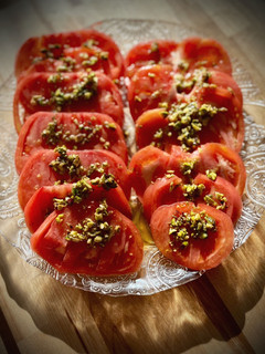 Una foto de Ensalada de tomate corazón de buey con vinagreta de pistachos
