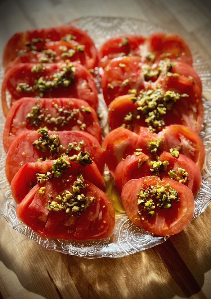 Una foto de Ensalada de tomate corazón de buey con vinagreta de pistachos