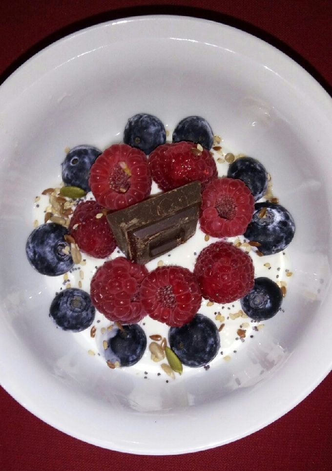 Una foto de Yogur griego con frutos rojos y semillas