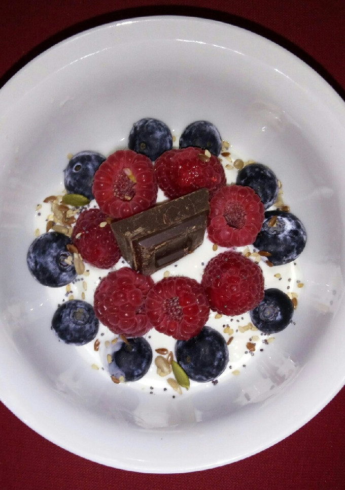 Una foto de Yogur griego con frutos rojos y semillas