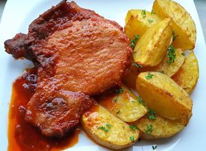 O poză a rețetei Cotlet de porc cu sos și cartofi la cuptor.