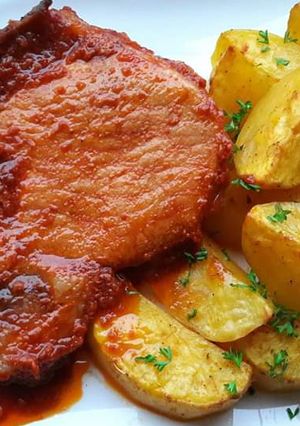 O poză a rețetei Cotlet de porc cu sos și cartofi la cuptor.