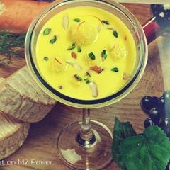 A picture of Coconut Mawa balls immersed in Creamy Coconut saffron milk.
