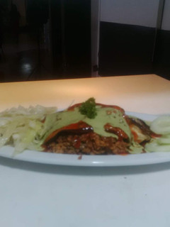 Una foto de Pasticho de berenjena relleno de carne de soya con vegetales y salsa napolitana y salsa de albahaca fresca