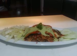 Una foto de Pasticho de berenjena relleno de carne de soya con vegetales y salsa napolitana y salsa de albahaca fresca