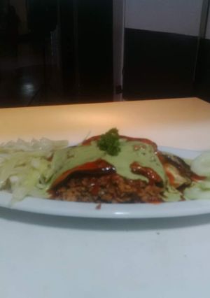 Una foto de Pasticho de berenjena relleno de carne de soya con vegetales y salsa napolitana y salsa de albahaca fresca