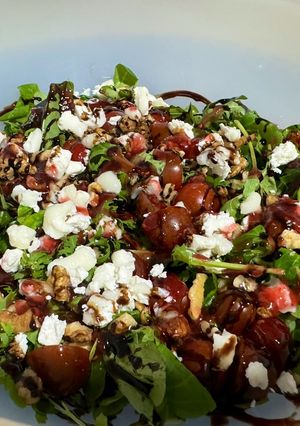 Una foto de Ensalada de canónigos con queso de cabra, nueces y mermelada de frambuesa