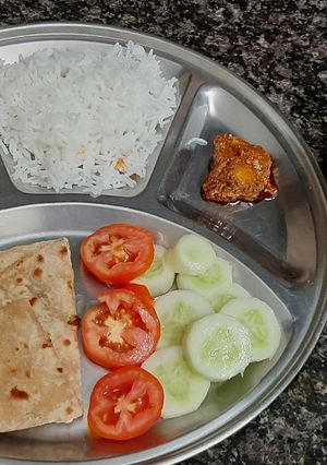 A picture of Simiple veg thali lunch with bhindi roti rice mango juice.