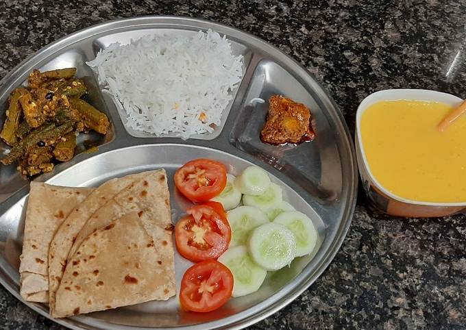 Simiple veg thali lunch with bhindi roti rice mango juice