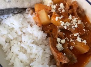 Una foto de Carne de res con salsa roja y papas