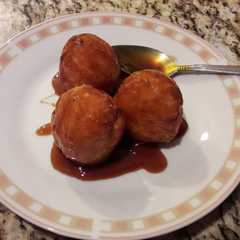 Una foto de Buñuelos de yuca en almíbar de papelón y anís dulce