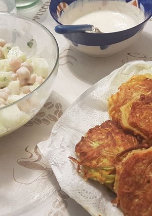 Una foto de Tortitas de calabacín y zanahoria con ensalada de garbanzo y pepino