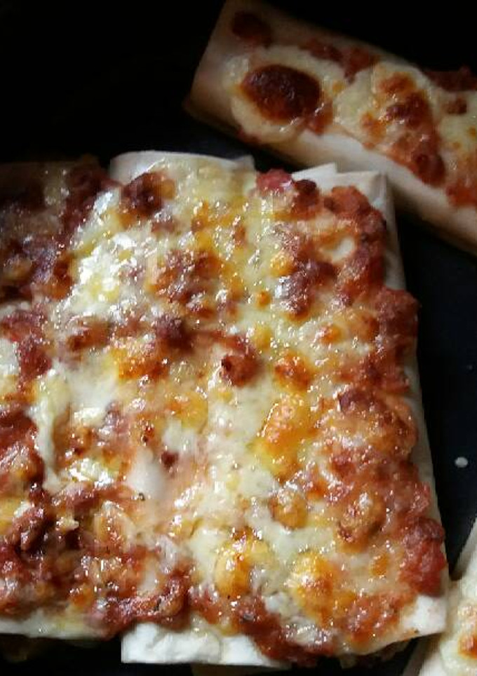 Una foto de Canelones de carne y huevo fáciles bañados en salsa boloñesa