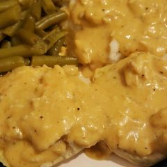 A picture of Chicken gravy over biscuits with green beans.