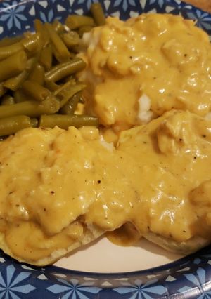 A picture of Chicken gravy over biscuits with green beans.