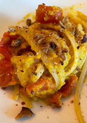 Foto di Linguine con crema di peperone giallo e alici, pomodorini confit, pane nero tostato e lime