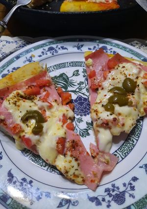 Una foto de Pizza con tomate picado, jamón, queso y olivas