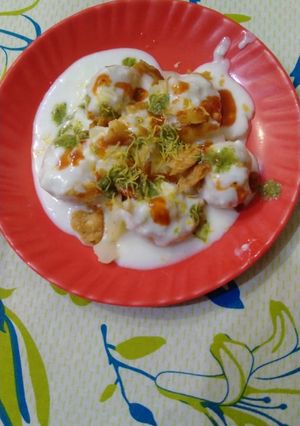 A picture of Dahi bhalla with green and red chutney.