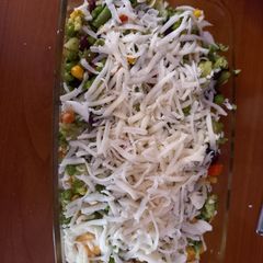 A picture of Cooked veggies with eggs and cheese.