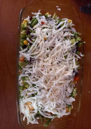 A picture of Cooked veggies with eggs and cheese.