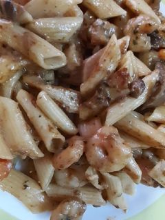 Una foto de Plumas con colas de langostinos y salsa de setas