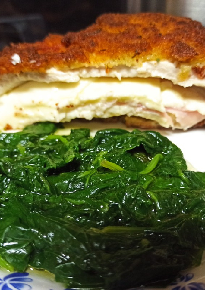Una foto de Pechuga de pollo rellena con guarnición de espinacas