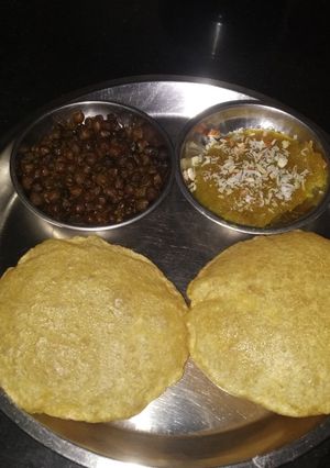 A picture of Ashtami special prasaad the puri chana and halwa thali.