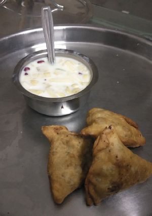 A picture of Samosa with fruit salad.