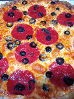 Una foto de Pizza de salami y olivas