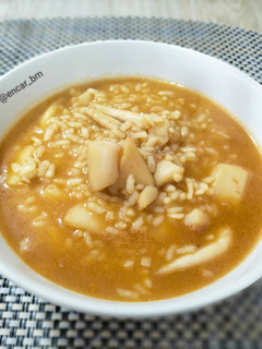 Una foto de Arroz caldoso con sepia y caldo de alga fucus con azafrán