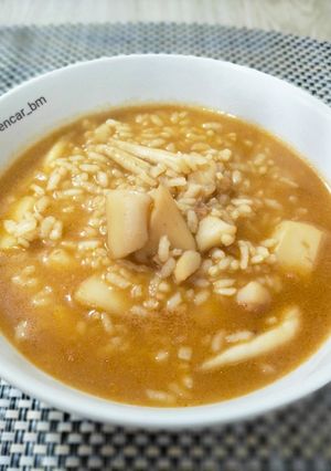 Una foto de Arroz caldoso con sepia y caldo de alga fucus con azafrán