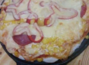 Una foto de Pizza piña salami choclo pimentón