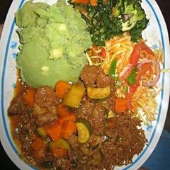 Mukimo served with beef stew and green vegetables A picture of Mukimo served with beef stew and green vegetables.