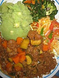 A picture of Mukimo served with beef stew and green vegetables.