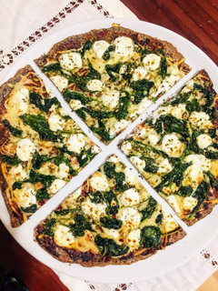 Una foto de Pizza de masa de quinoa con espinacas y queso de cabra