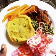 A picture of Mashed potatoes served with peas and meat.