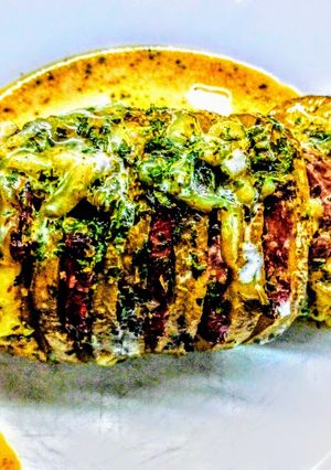 Una foto de Papas bandoneon con panceta y queso parmesano