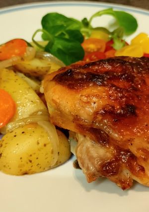 A picture of Chicken thighs in "onion" mayonnaise with vegetables, in the oven.