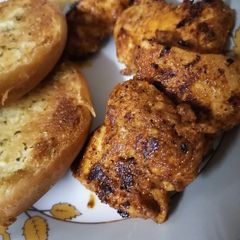 A picture of Hot Chicken with garlic bread 🍞🍗🐔.