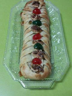 Una foto de Trenza de masa brisa rellena de membrillo y adornada con nueces y cerezas confitadas